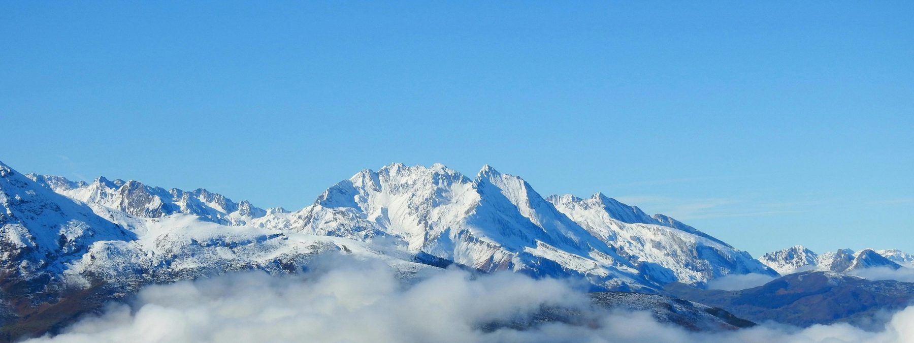 Sommet enneigé des Pyrénées émergeant des nuages