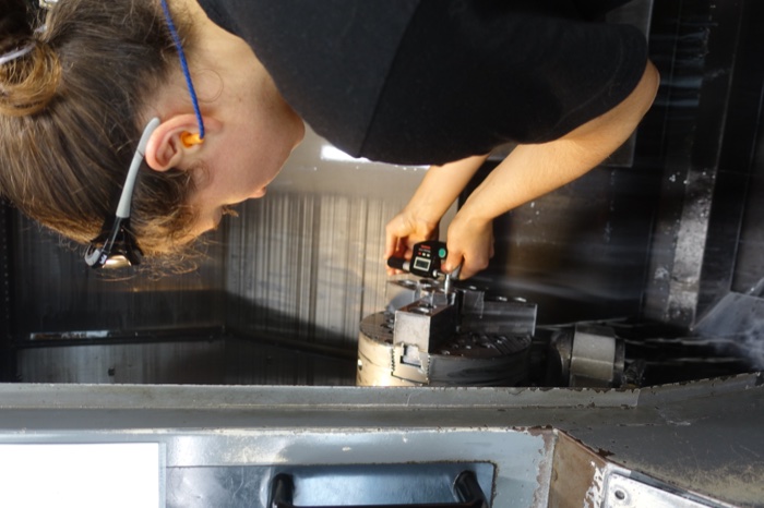 Technicienne au contrôle métrologique d'une pièce